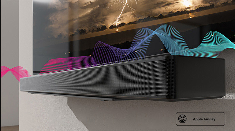 На стене закреплен саундбар, а прямо над ним — телевизор. Между ними двигаются звуковые волны, меняющие свой цвет с красного на синий.