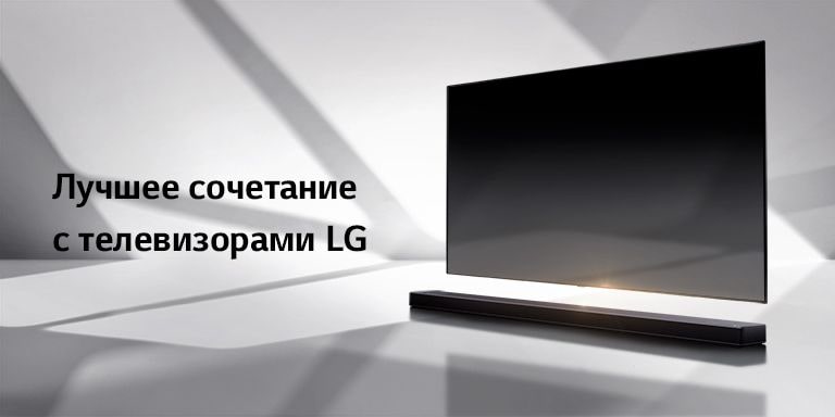 Саундбар и телевизор на белом полу с тенью, отбрасываемой снаружи справа.