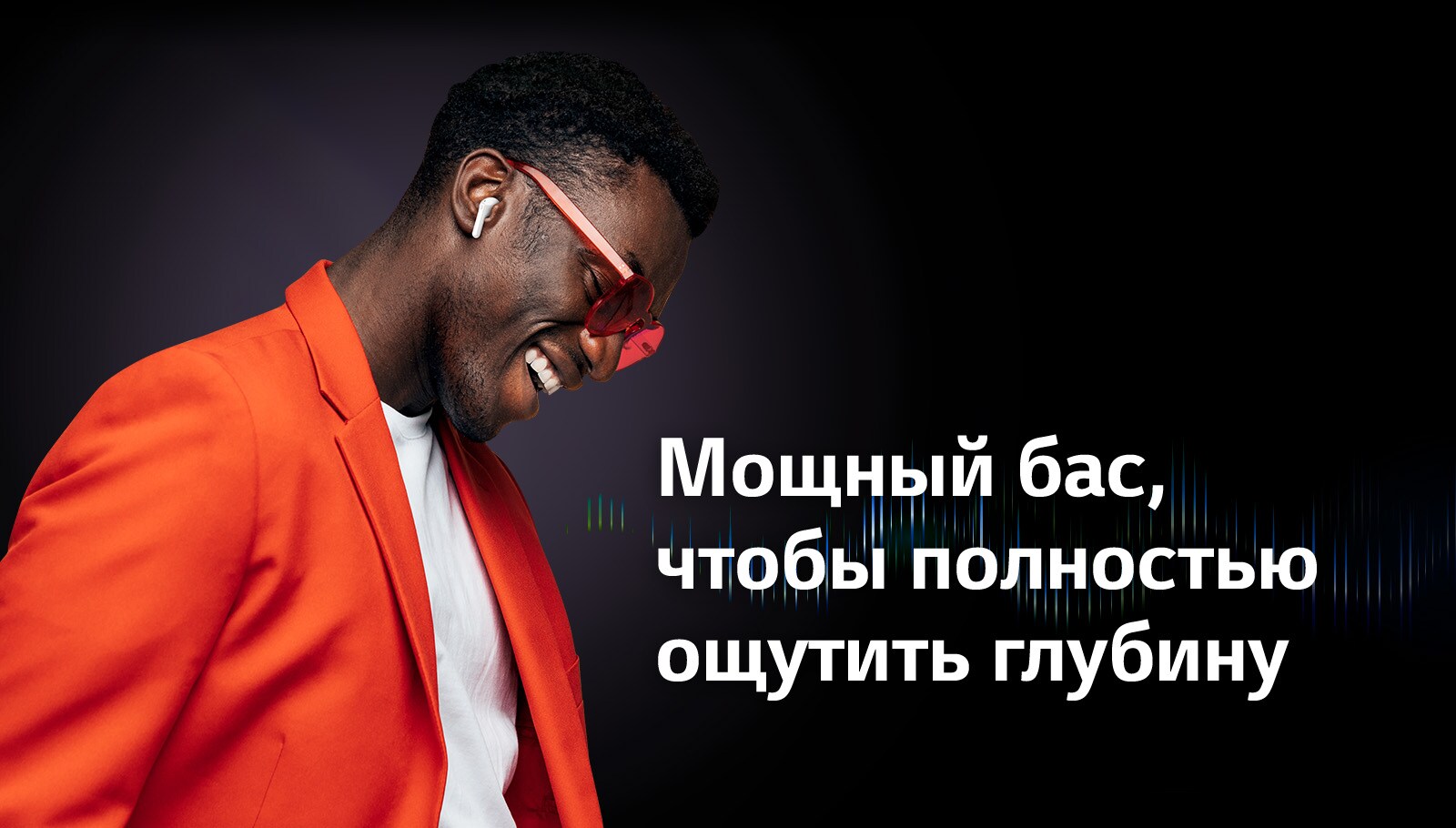 Мужчина в оранжевом костюме слушает музыку в наушниках TONE Free.