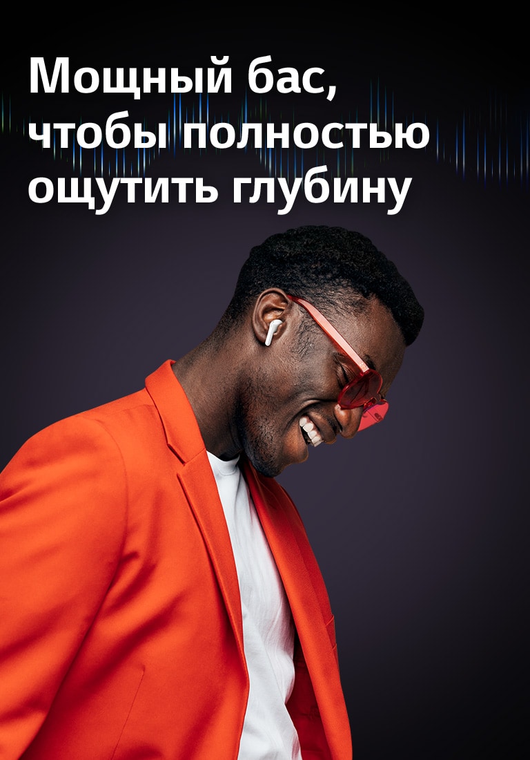 Мужчина в оранжевом костюме слушает музыку в наушниках TONE Free.