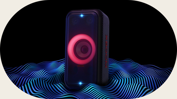 LG XBOOM XL5T стоит в бескрайнем пространстве. Включена красная подсветка сабвуфера и двойной стробоскоп. Сверху колонки отображается звуковой эквалайзер. От нижней части динамика исходят звуковые волны, подчёркивающие глубокий бас.
