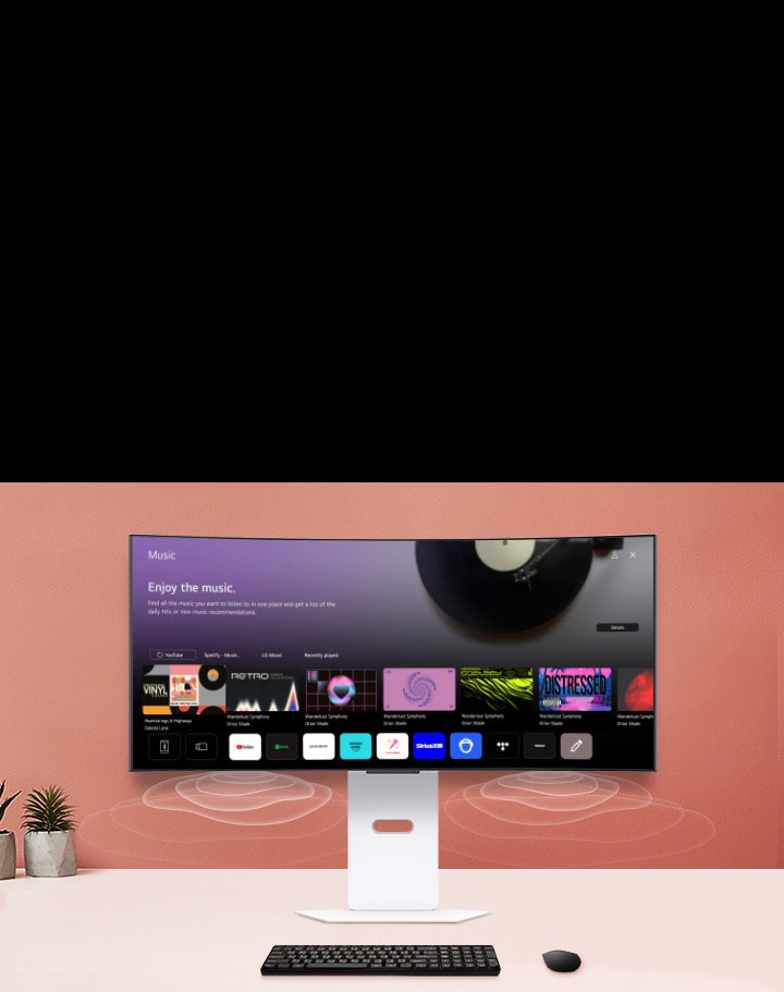 На экране смарт-монитора, размещенного на столе, изображен экран MUSIC APP.