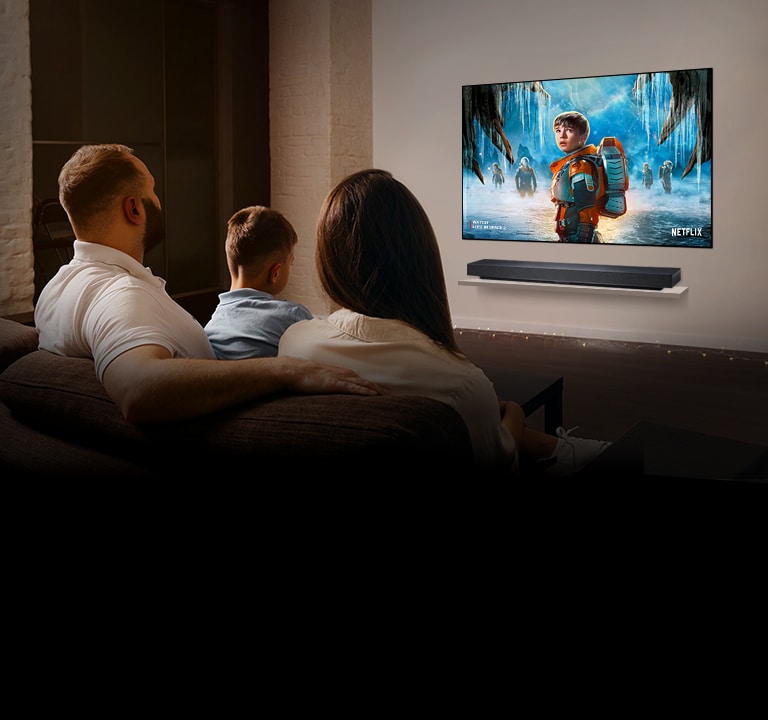 Пара сидит на диване в гостиной и смотрит романтический фильм по телевизору.