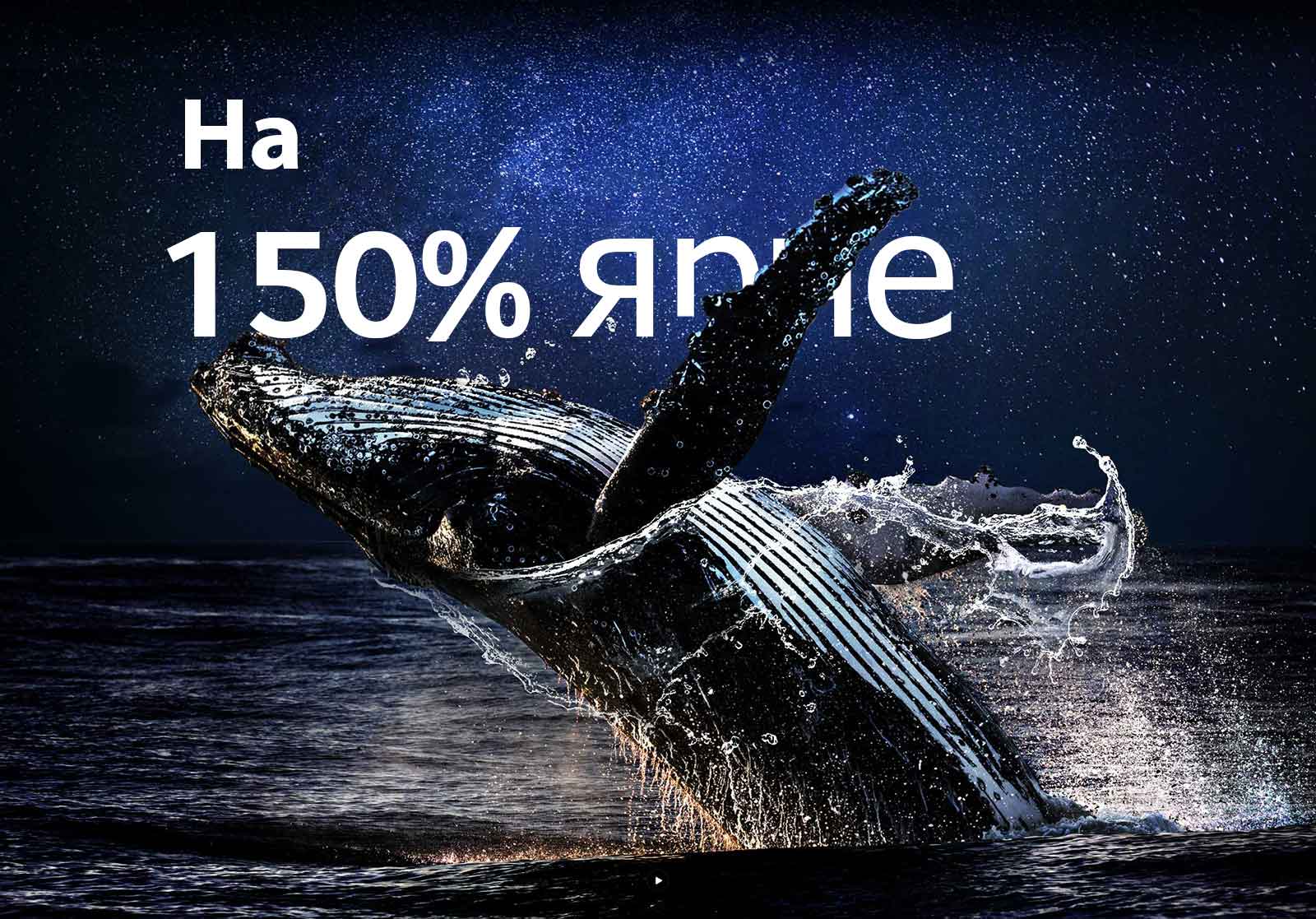 Кит, выпрыгивающий из океана на фоне черного неба. Слова «на 150% ярче» появляются над китом и становятся ярче.