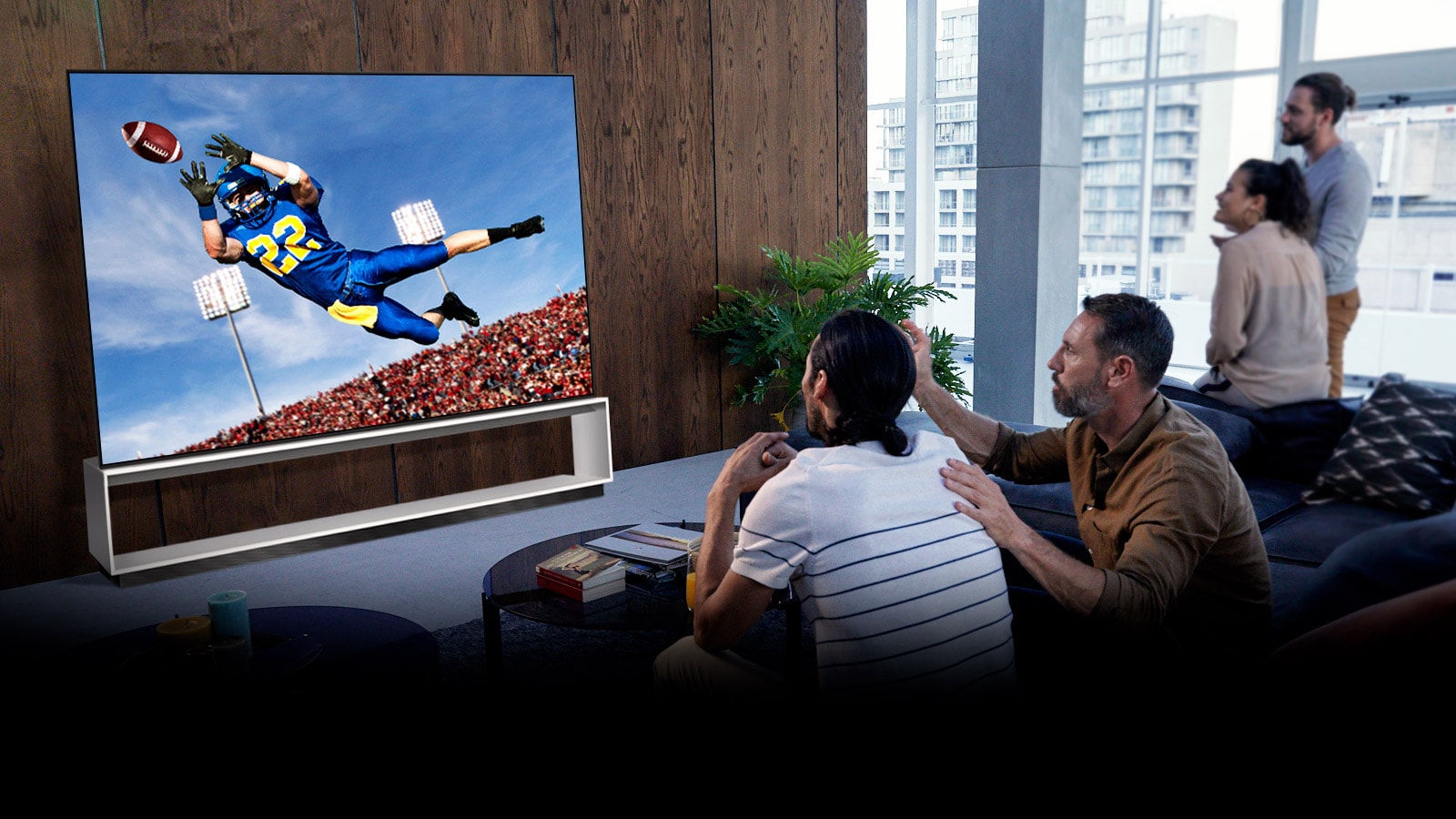 Люди смотрят матч с участием команды Тоттенхэм по телевизору в гостиной