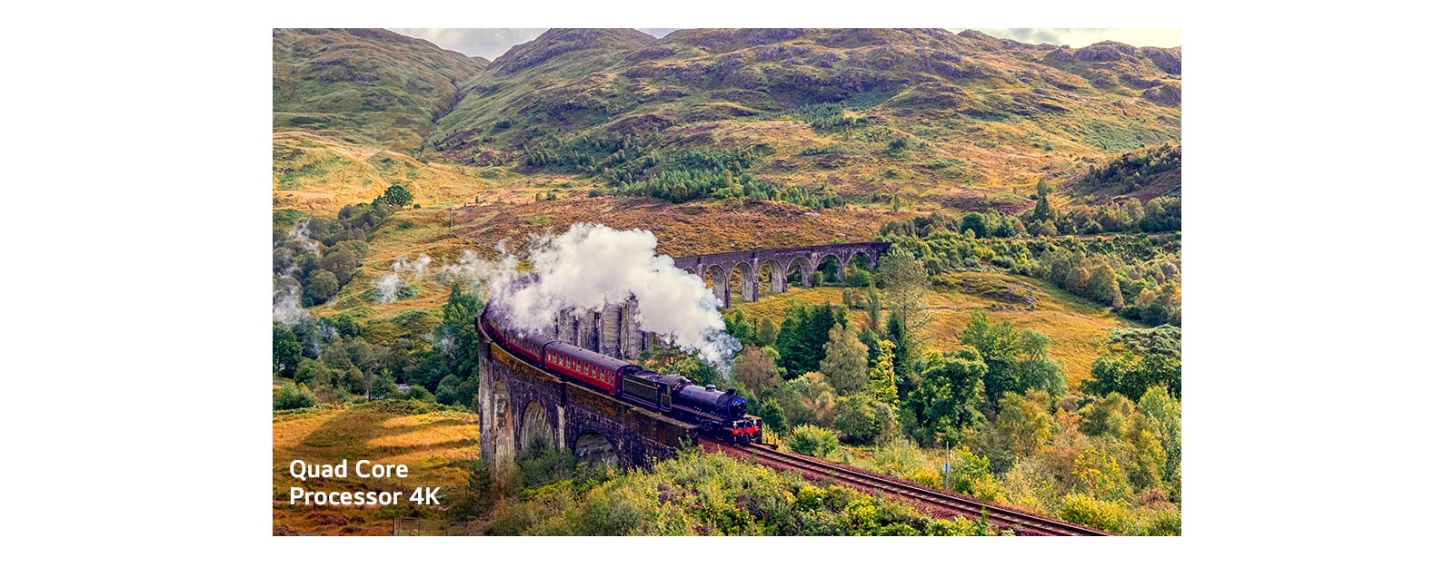 Поезд, испускающий пар на рельсах, находится в середине горы с надписью Quard Core Processor 4K в левом нижнем углу.