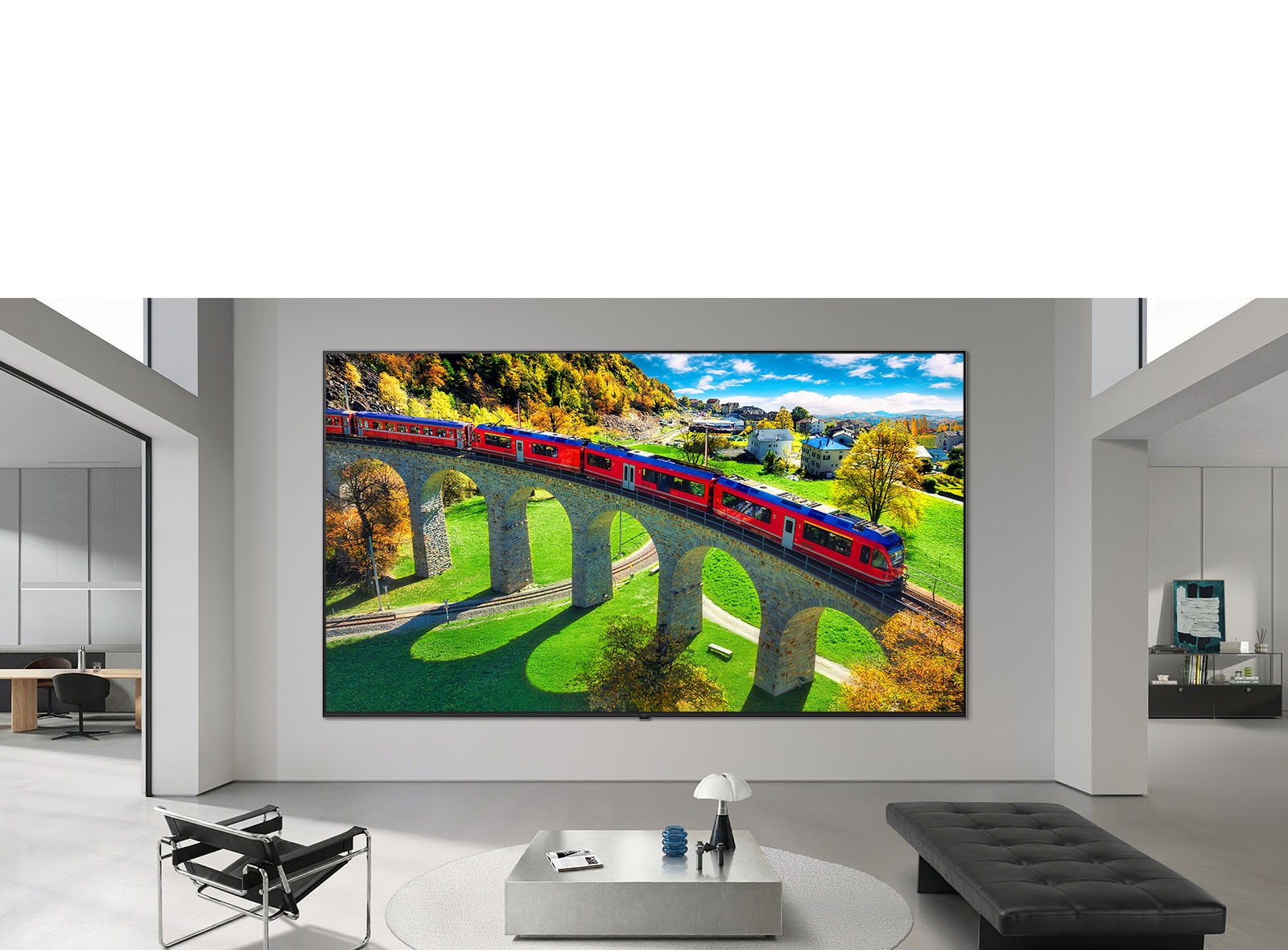 Телевизор LG Micro RGB evo AI MRGB95 с диагональю до 100 дюймов закреплен на стене в просторной современной гостиной. Отображается яркий красочный пейзаж, подчеркивающий насыщенные цвета и мелкие детали, поднимая интерьер на новый уровень. 