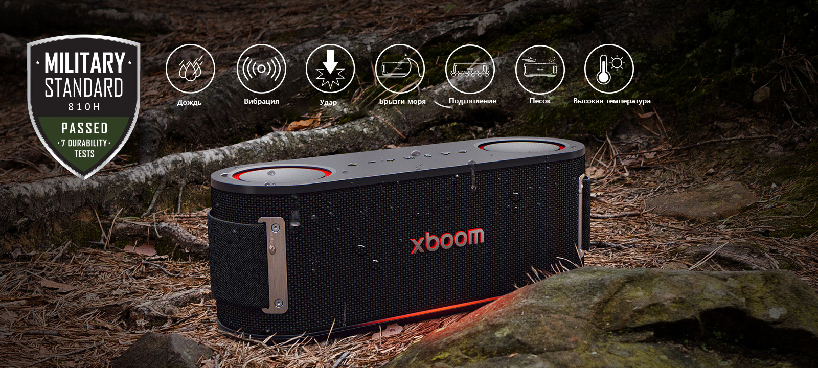 LG xboom Bounce размещается на почве, покрытой влажными листьями, между корнем дерева и камнем. Вверху слева расположен лого Military Standard.