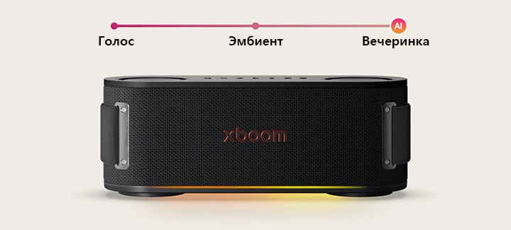 В комнате, наполненной красным освещением, позади расположены черный диван, черный пуфик и черное кресло. На переднем плане xboom Bounce расположен на вершине черного круглого стола.