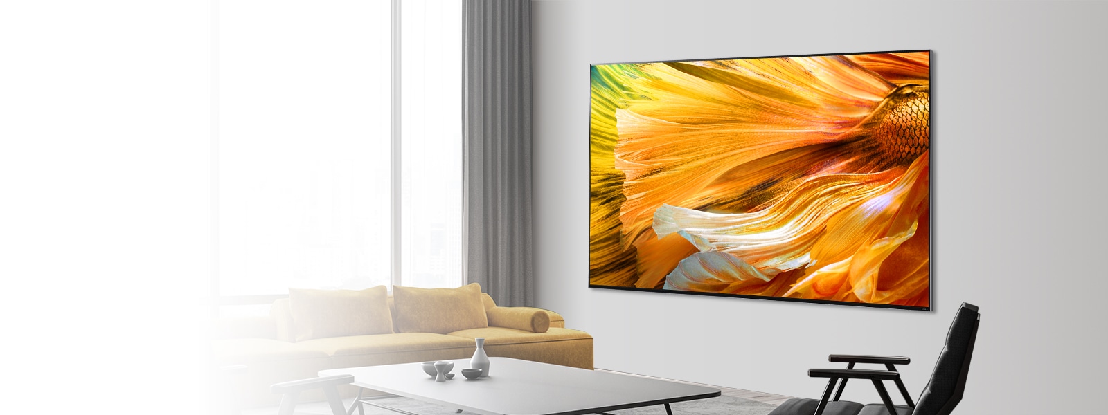 Изображение телевизора LG QNED MiniLED с большим экраном, закрепленного на серой стене.  Перед телевизором расставлены диван, журнальный столик и стулья.