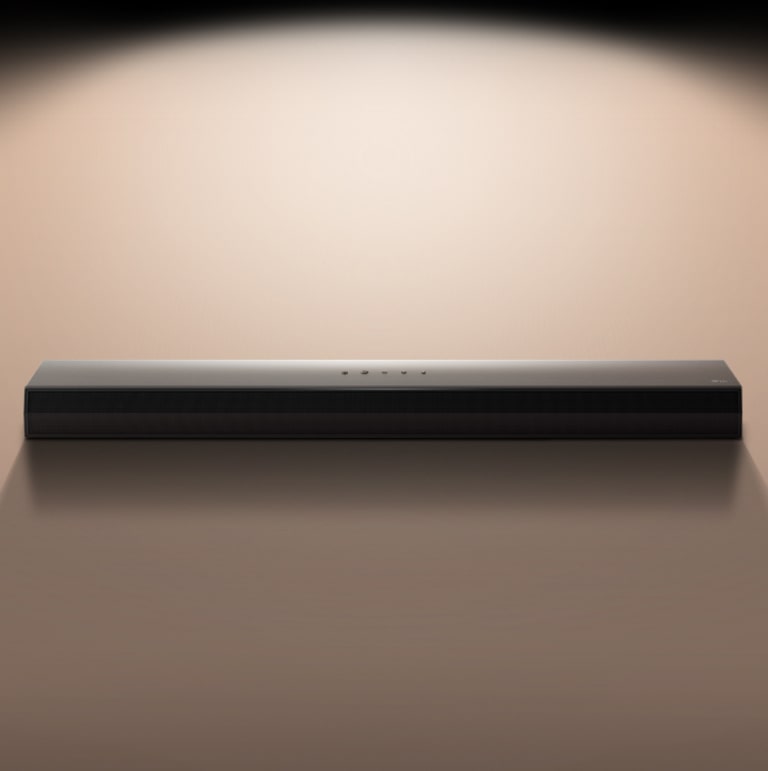 Звуковая панель LG Soundbar на черном фоне, подсвеченная прожектором.