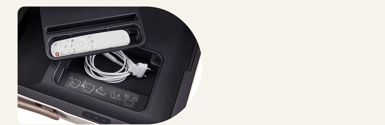 Крупный план LG StanbyME Go с демонстрацией встроенных отделений. Пульт дистанционного управления LG находится внутри меньшего отделения, а кабель питания — внизу. Внутри кармана прикреплена предупреждающая наклейка.