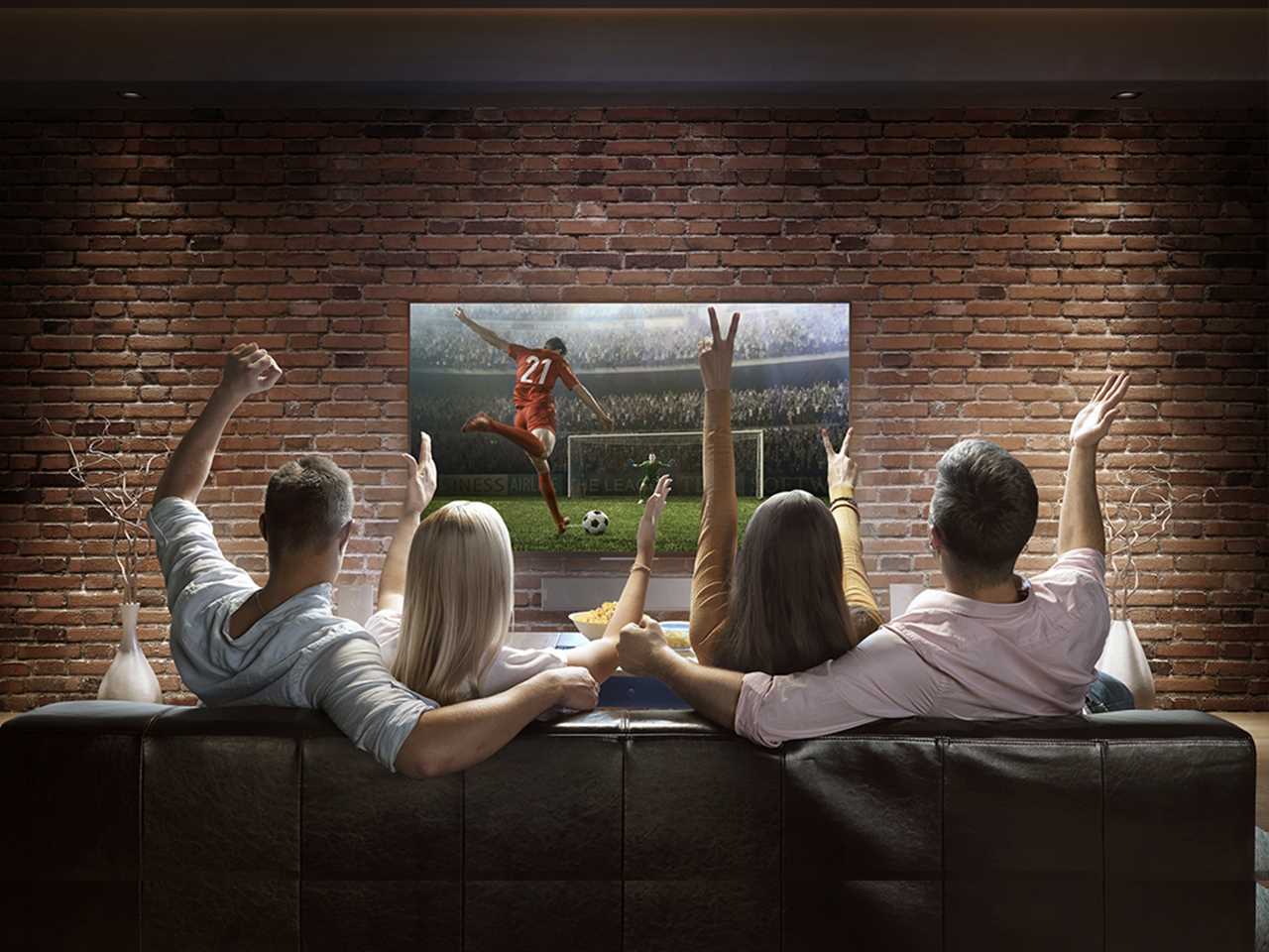 Компания друзей смотрит спортивный матч на телевизоре LG SUPER UHD 4K.