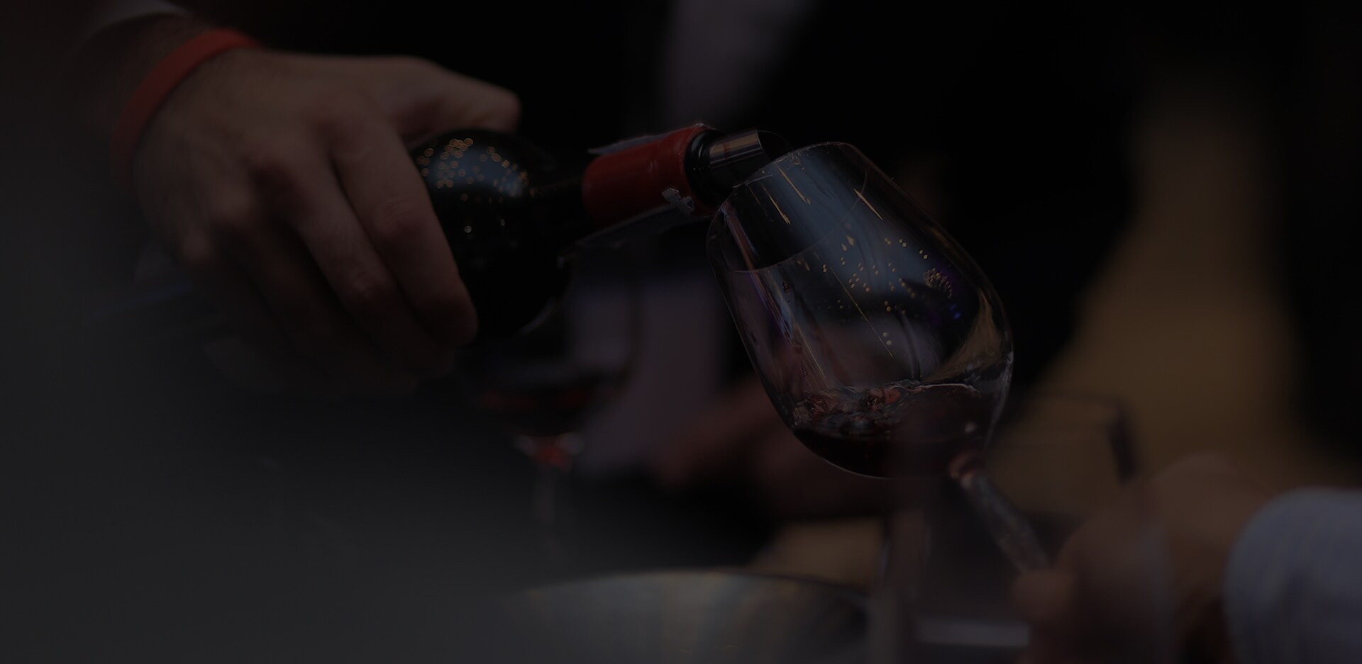 James Suckling is pouring wine into the wine glass.