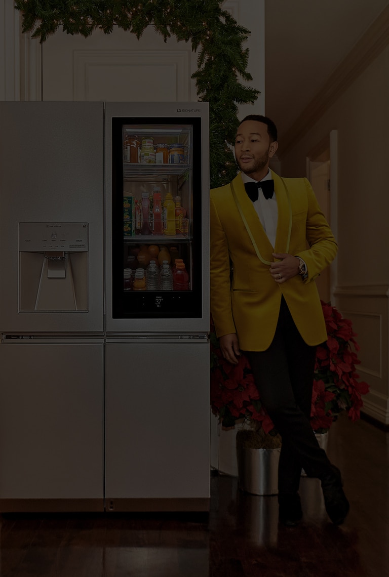 Певец Джон Ледженд опирается на холодильник LG SIGNATURE.