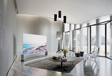 Телевизор LG SIGNATURE OLED 8K расположен в современной роскошной гостиной с предметами меблировки от Kartell.