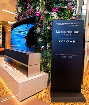 Знак с изображением коллекции LG SIGNATURE и BVLGARI возле сворачивающегося телевизора OLED R.
