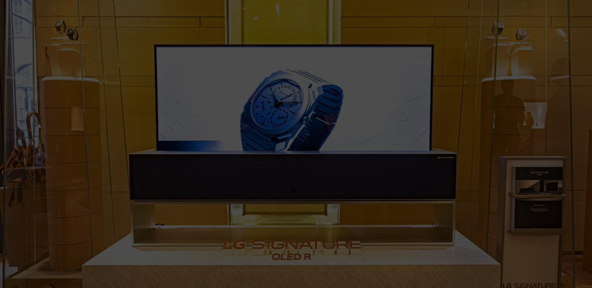 Название статьи поверх изображения сворачивающегося телевизора OLED TV R с часами BVLGARI на экране.