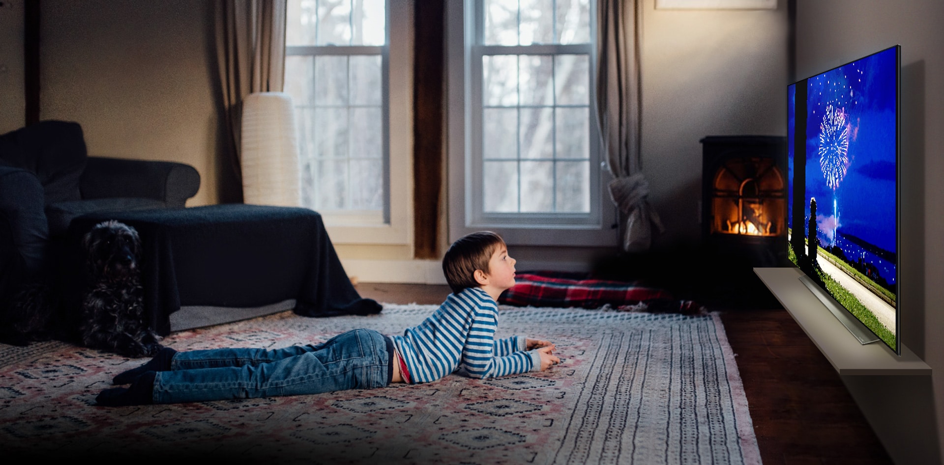 Boy lying on his stomach on the rug watching animation on a Blue Light-less TV