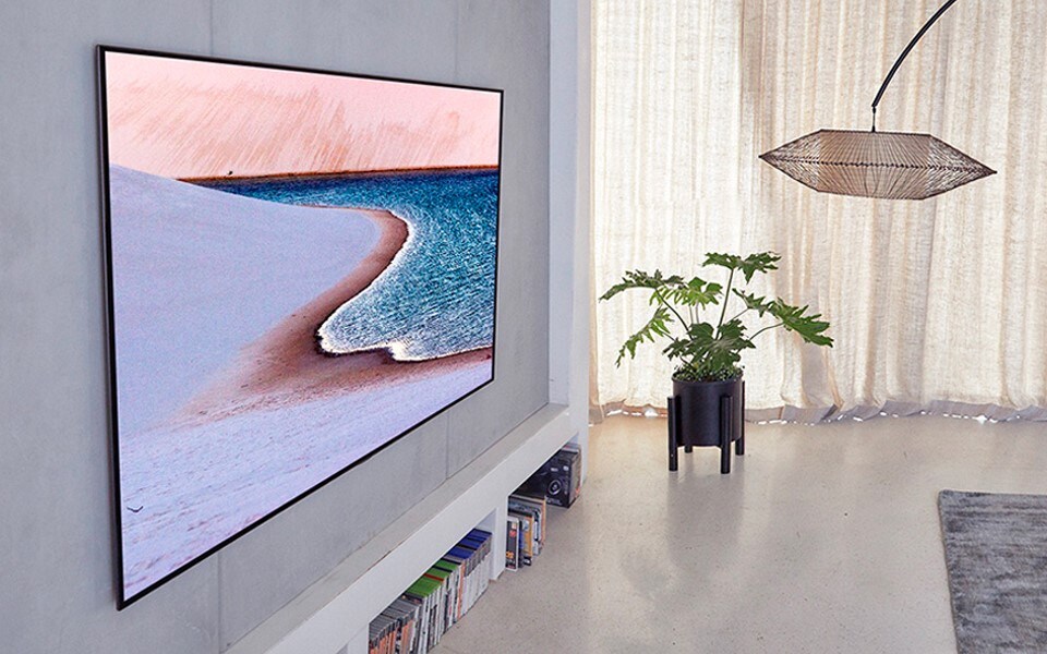 The LG OLED TV, displaying image of a beach shoreline, in a home living space.