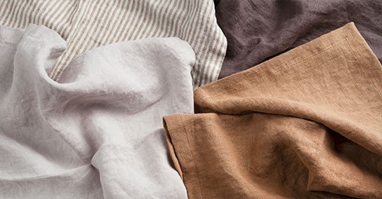 Bild av fyra kläder i beige rand, vit, brun och mörkbrun färg