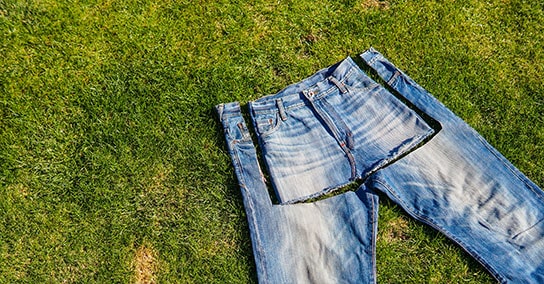 Bild av jeans som skärs i kjol på marken