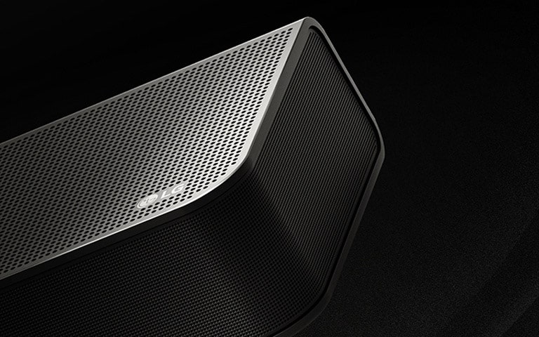 LG Soundbar na čiernom pozadí odhaľuje svoj dizajn, pričom začína na hornej strane a postupuje k okraju. Zo stredu a z koncov soundbaru vychádzajú biele kvapôčky ako vodopád a znázorňujú horný výstup zvuku.