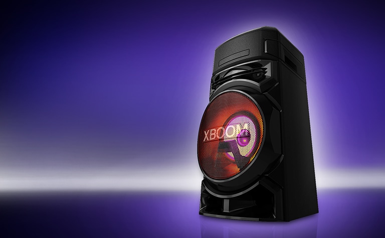 Pohľad zdola na pravú stranu reproduktora LG XBOOM na fialovom pozadí.  Svetlá na reproduktore XBOOM sú červené