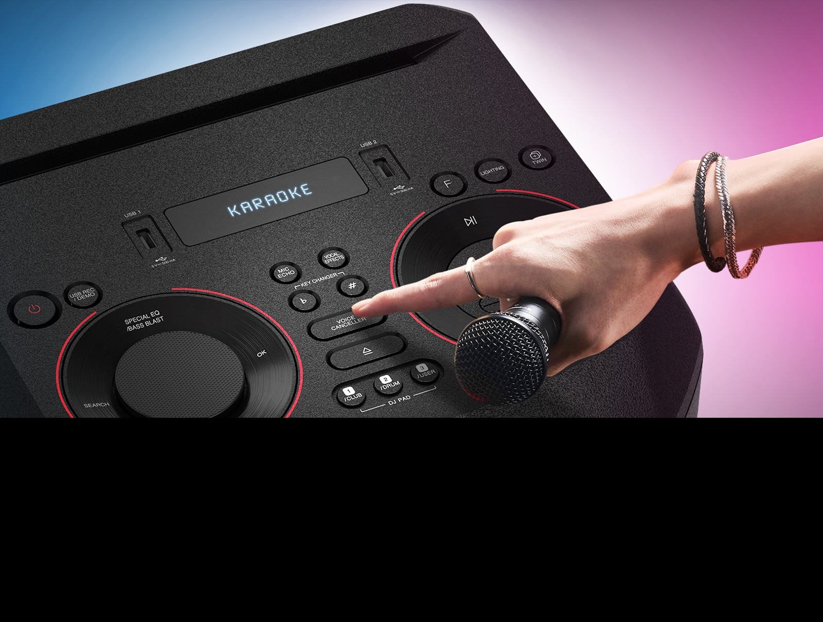 Ruka držiaca mikrofón stláča tlačidlo funkcie na odstránenie hlasu zo skladby v hornej časti reproduktora LG XBOOM.