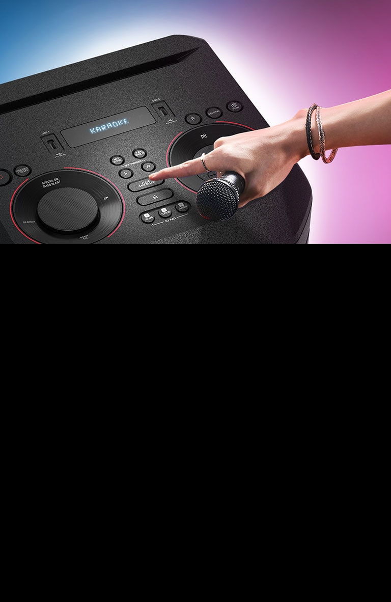 Ruka držiaca mikrofón stláča tlačidlo funkcie na odstránenie hlasu zo skladby v hornej časti reproduktora LG XBOOM.