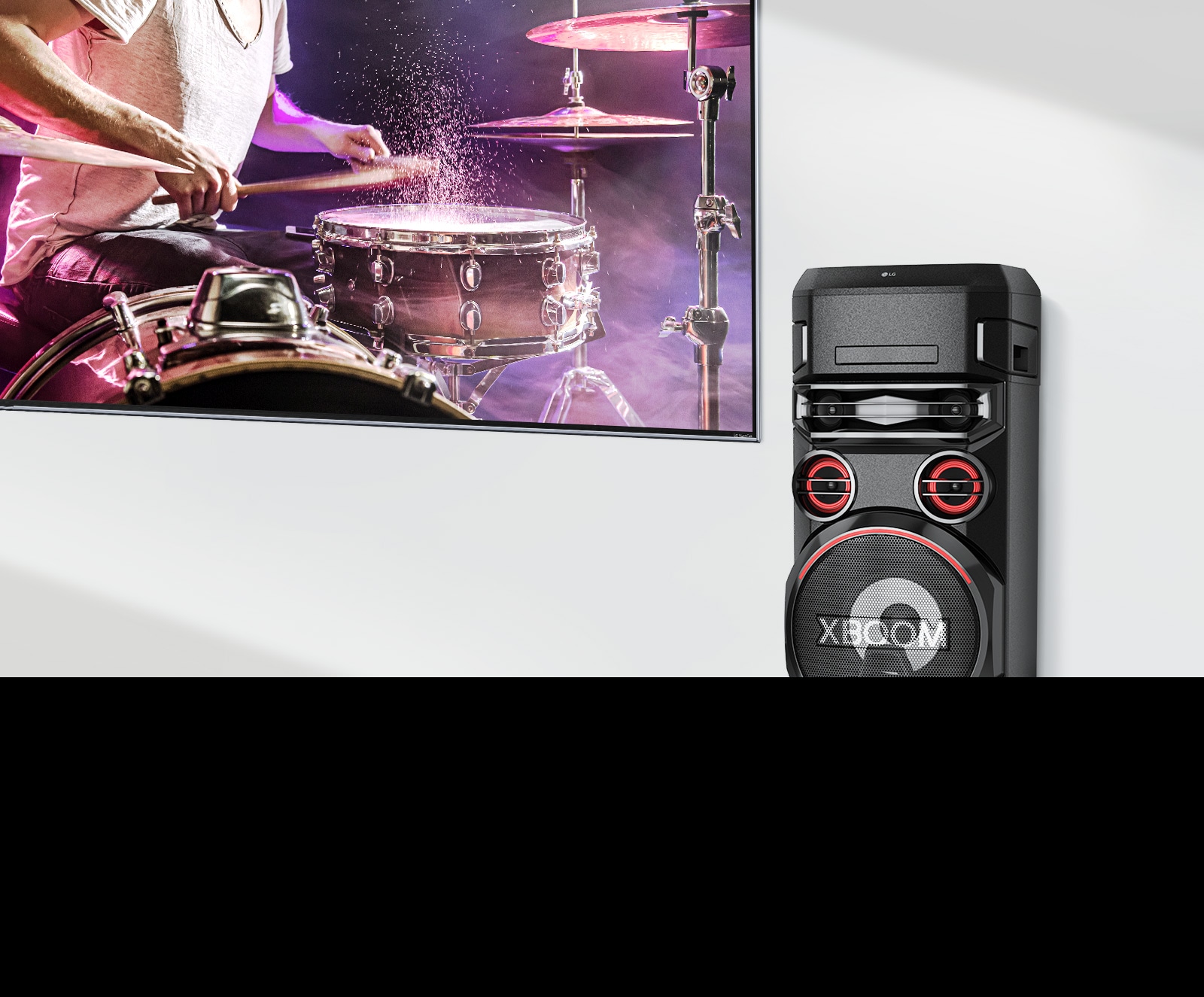 Televízor osadený na stene s reproduktorom LG XBOOM na pravej strane.