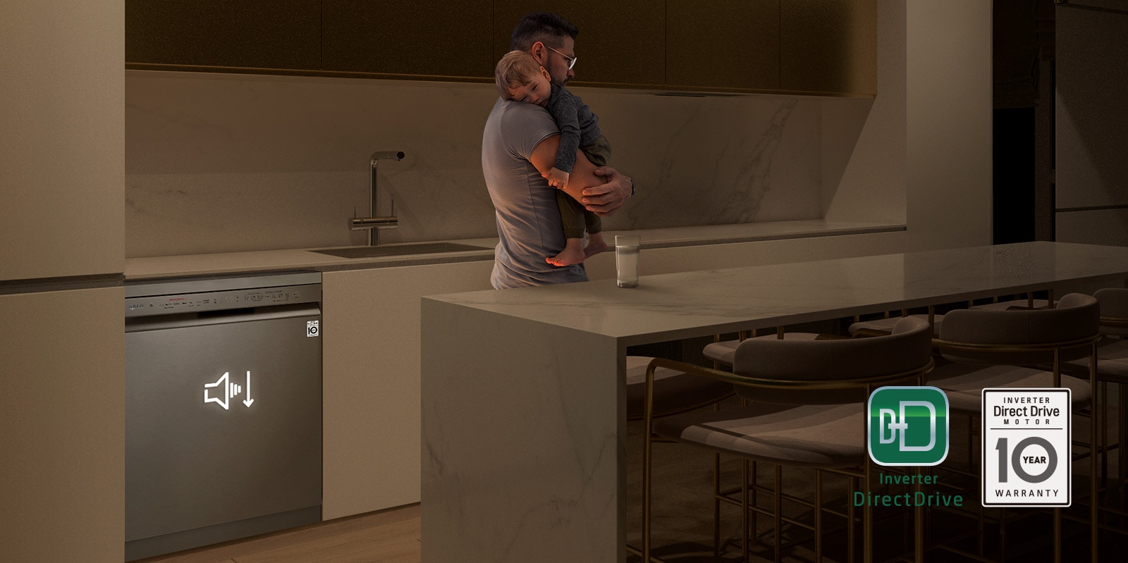 Muž, ktorý držal spiace dieťa v spore osvetlenej kuchyni, v pozadí ticho pracuje umývačka.