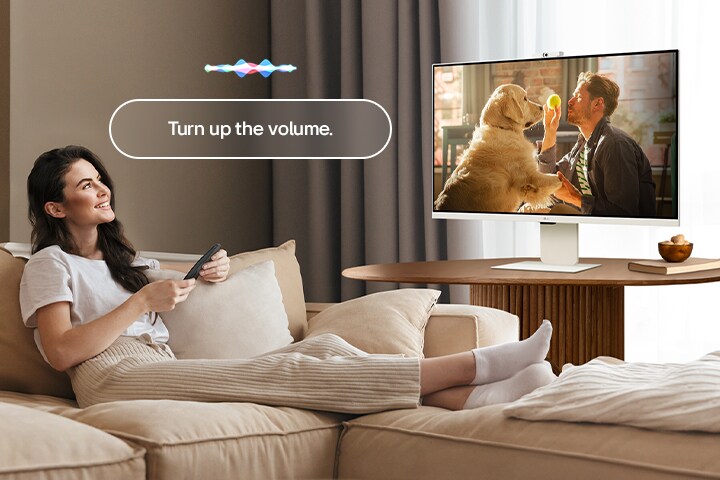 Žena zvyšuje hlasitosť monitora LG Smart Monitor ovládačom Magic Remote.