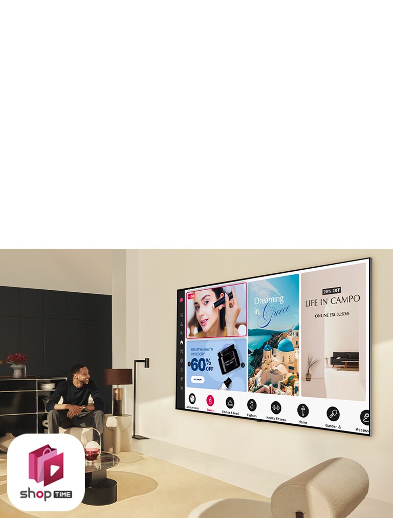 Manželský pár si pozerá domáce nákupné kanály na veľkom nástennom televízore LG v modernej obývacej miestnosti.