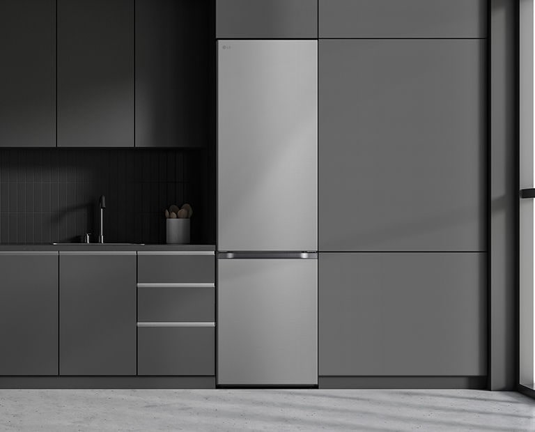 Moderná kuchyňa s chladničkou, ktorá plynule zapadá do okolitého nábytku a pripomína vstavaný model.