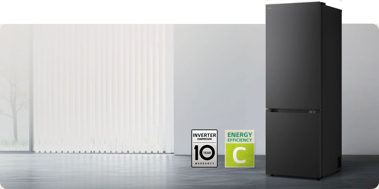 Matná čierna chladnička so spodnou mrazničkou LG (GBBW726AEV), pohľad spredu v svetlej miestnosti s vertikálnymi žalúziami s ikonami 10-ročnej záruky na kompresor a energetickej účinnosti A dole