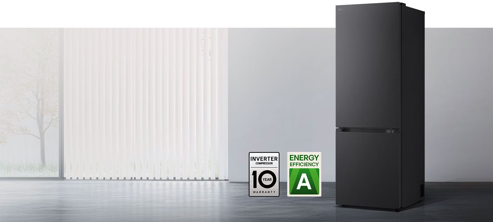 Matná čierna chladnička so spodnou mrazničkou LG (GBBW726AEV), pohľad spredu v svetlej miestnosti s vertikálnymi žalúziami s ikonami 10-ročnej záruky na kompresor a energetickej účinnosti A dole