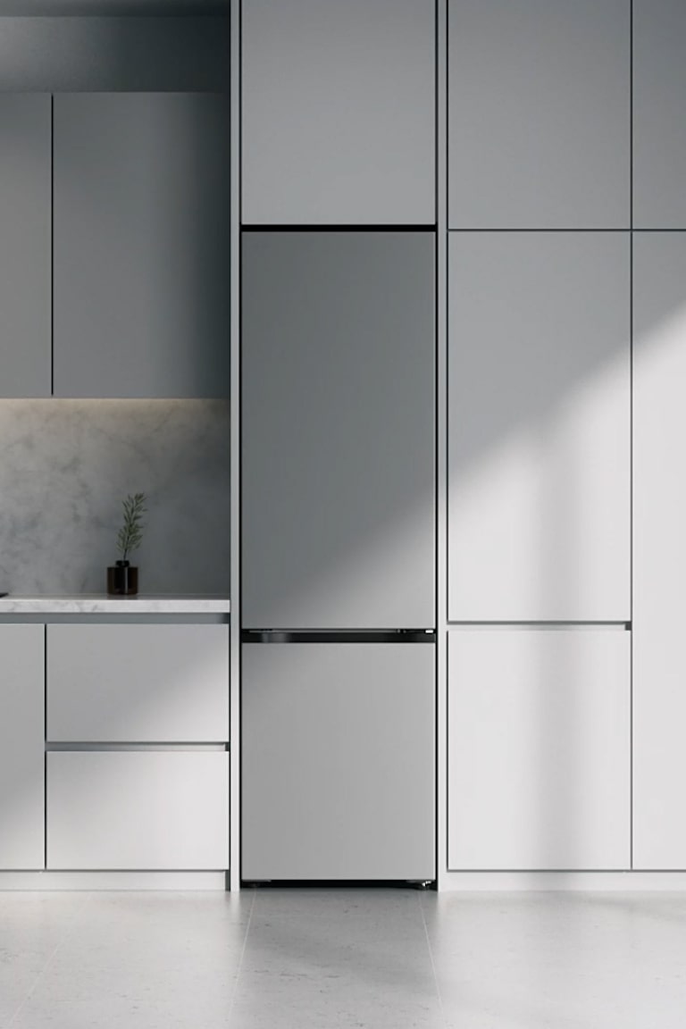 Chladnička vo farbe Prime Silver so spodnou mrazničkou LG (GBBW726CPY) vstavaná v sivých skrinkách vedľa mramorovej pracovnej dosky s indukčnou varnou doskou a veľkým oknom vpravo