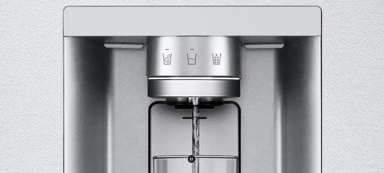 Záber sa približuje na dávkovač vody. Vonkajšia strana chladničky sa spriehľadní a teraz je vidieť vnútro dvierok a mechanické časti trysky dávkovača. Video sa ďalej približuje, aby sa zobrazili kvapôčky vody, prepadajúca UVnano časťou trysky, ktorá redukuje baktérie. Pohľad sa oddiali, aby bolo možné znovu vidieť vonkajšiu časť chladničky, pričom sa voda nalieva do pohára.