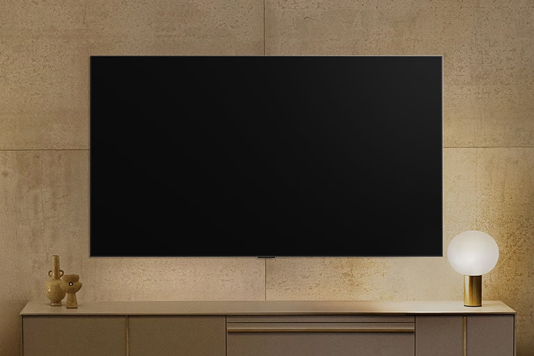 Televízor LG TV nainštalovaný na stene vyzerá byť vypnutý, ale zapne sa funkcia Always Ready. Zobrazuje informácie a potom striedavo zobrazuje rôzne umelecké diela.