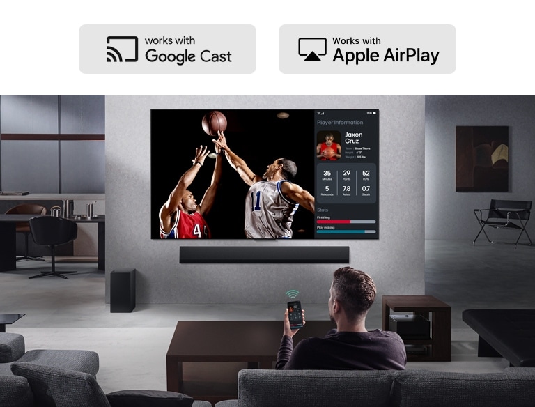 Osoba v obývačke drží svoj telefón. Na telefóne je ikona vysielania ukazujúca, že obrazovka telefónu je zrkadlená na televízore. Na televízore je basketbalový zápas, vedľa je zrkadlená obrazovka ukazujúca štatistiky hráčov. 