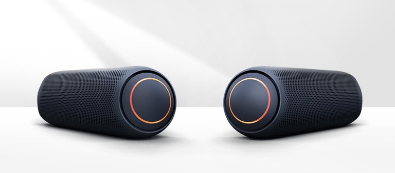 Na bielom pozadí sú zobrazené dve zariadenia XBOOM nasmerované na seba. Obe majú červené osvetlenie.