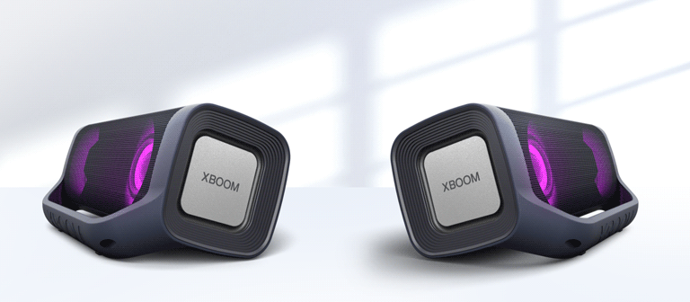 Na bielom pozadí sú zobrazené dva reproduktory LG XBOOM Go smerujúce od seba. Oba majú purpurové osvetlenie.
