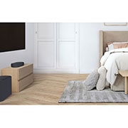 LG QP5 - LG Sound Bar LG, Bočný pohľad na Sound Bar a subwoofer umiestnené na drevenej skrinke v útulnej spálni, QP5, thumbnail 4