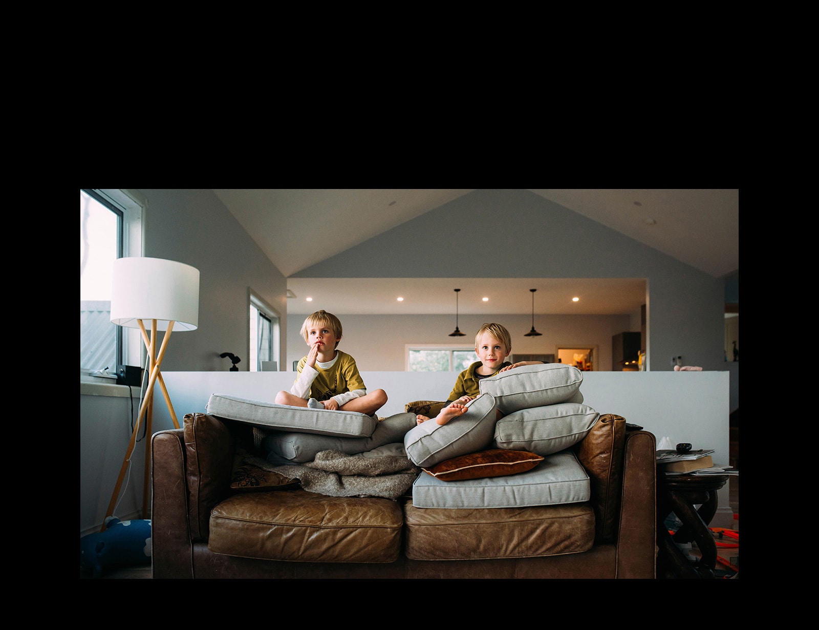 Dve dvojčatá sedia na pohovke a niečo sledujú.