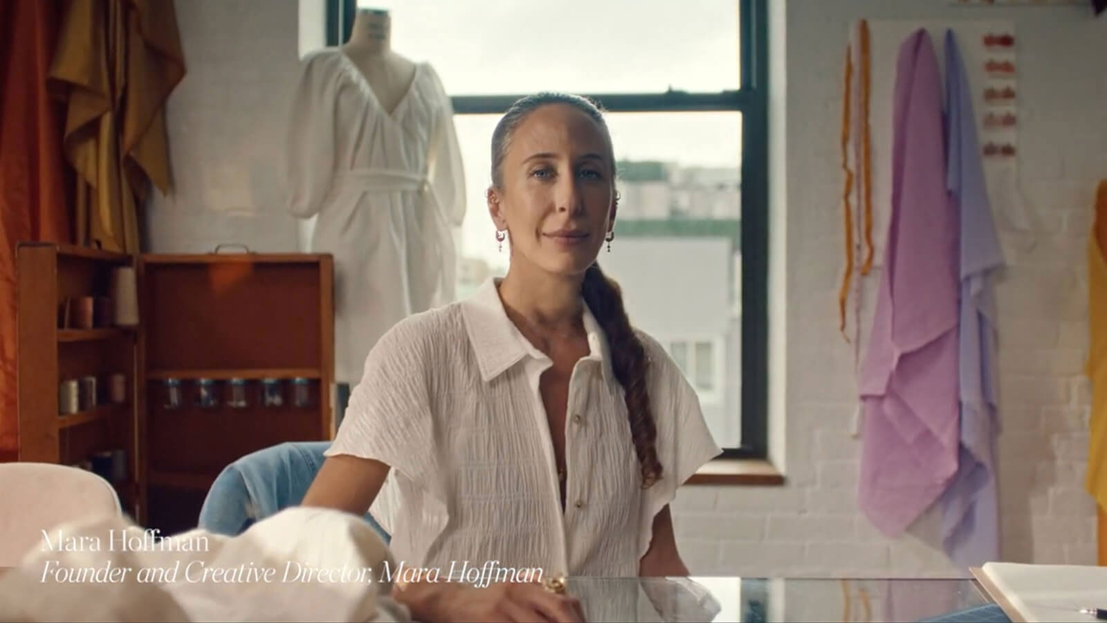 Zakladatelka a kreativní ředitelka módní značky „Mara Hoffman“ sedí a poskytuje rozhovor.