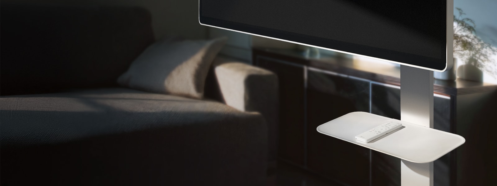 LG Smart Monitor Swing Stand Plate zobrazený s diaľkovým ovládačom, umiestnený v útulnej obývacej izbe. 