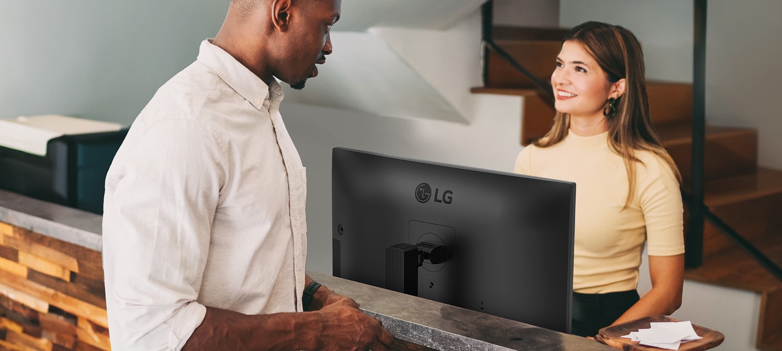 Recepčná sa rozpráva s mužom pri recepcii.