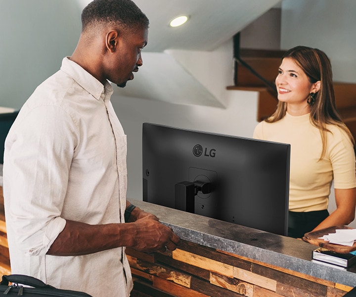 Recepčná sa rozpráva s mužom pri recepcii.