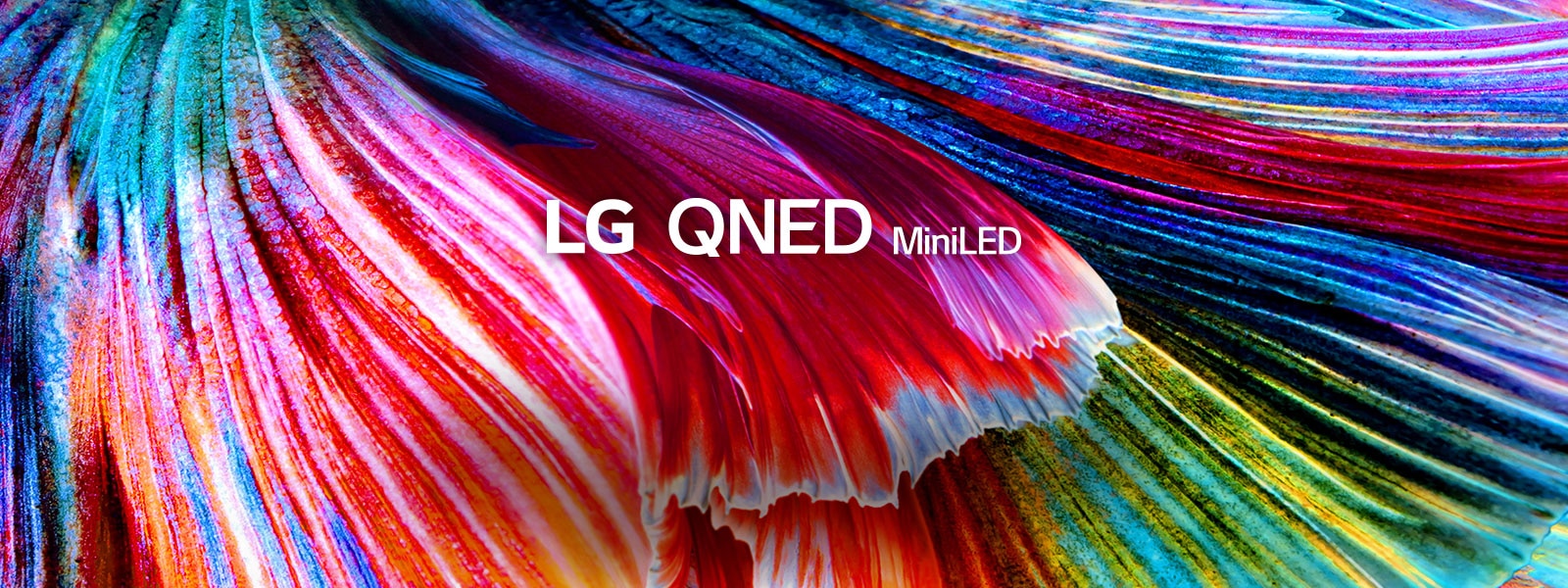 Záber zblízka na pestrofarebné vlny materiálu v odtieňoch červenej, modrej, zelenej a žltej.